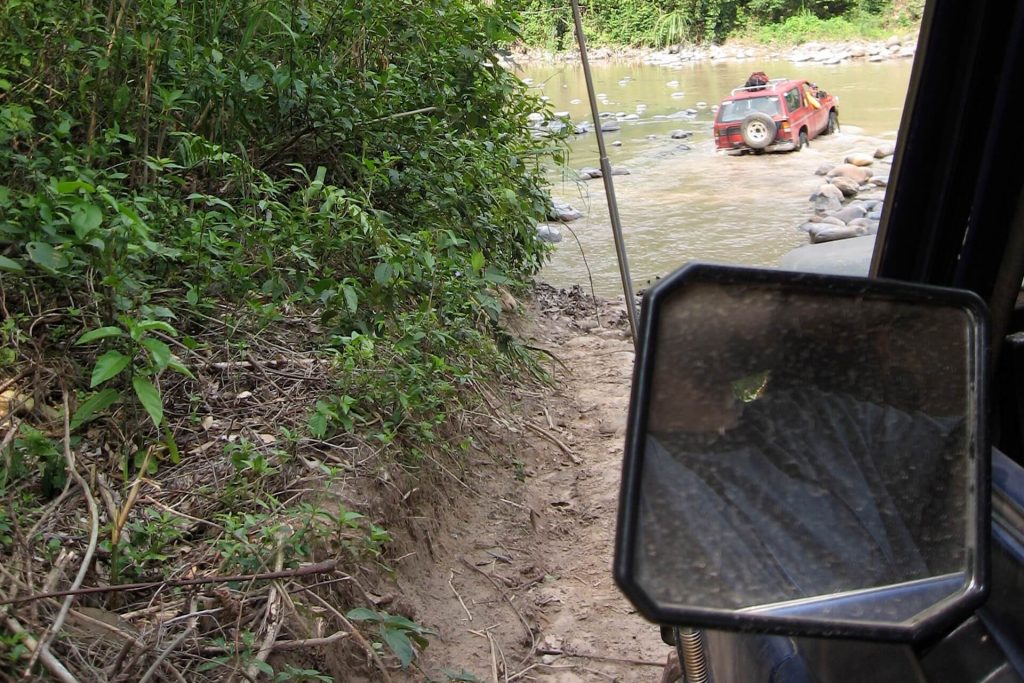 Een 4x4 gaat door een rivier in het Amboro National Park in Bolivia
